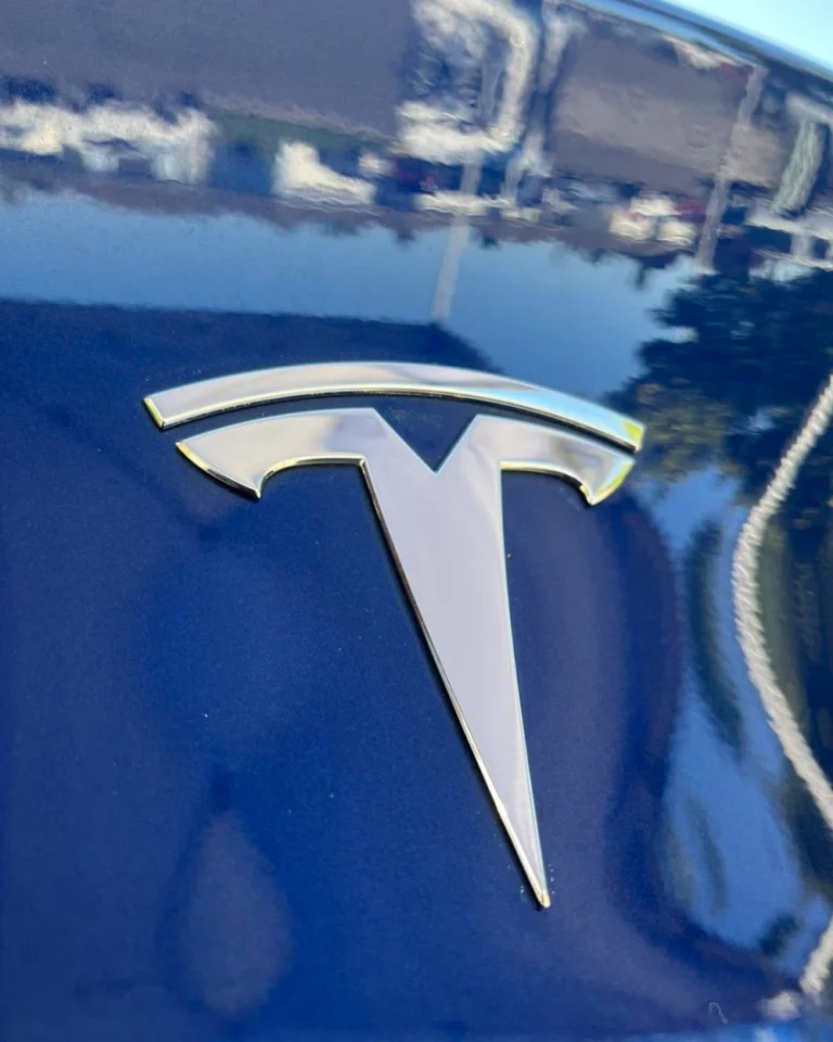 Glossy dark blue Tesla paint and badge after exterior detail